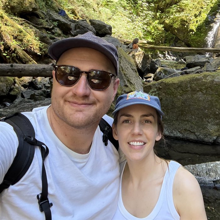 George Raymond and his wife at a waterfall in the Pacific Northwest